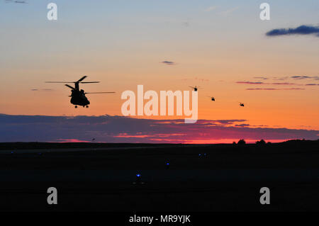 Tre UH-60 Blackhawks dal Maryland National Guard 224th del reggimento di aviazione lasciare su una missione per inserire le truppe in battaglia con un CH-147F Chinook dalla Royal Canadian Air Force 450 tattico squadrone di elicotteri a Camp Wainwright, Alberta, Canada, il 26 maggio 2017. Il 224th è il supporto di risolvere in acero 17, l'esercito canadese di premier di brigata di convalida a livello di esercizio progettata per affilare i singoli insiemi di competenze e migliorare la disponibilità unità di esecuzione 14-29 maggio. Foto Stock