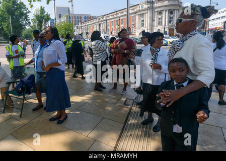 Londra, Regno Unito. 26 Maggio, 2018. Persone di ascoltare come un coro canta alla Brixton La Chiesa Avventista del Settimo Giorno 'Essere il cambiamento' evento in Piazza Windrush, Brixton contro la pistola e il coltello della criminalità. Essi avevano marciato la breve distanza della piazza della chiesa e sono state appena iniziando un programma di canto gospel, presentazioni e la preghiera per la comunità e per coloro che sono colpiti da questi crimini. Londra il tasso di omicidi è aumentata di oltre un terzo negli ultimi tre anni e lo scorso anno ha visto un aumento del 22% registrato nella criminalità coltello e 11% nella pistola criminalità. Credito: Peter Marshall / Alamy Live News Foto Stock