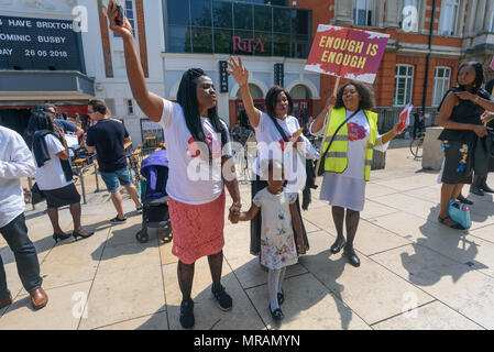 Londra, Regno Unito. 26 Maggio, 2018. Persone rasied le loro mani come il coro canta alla Brixton La Chiesa Avventista del Settimo Giorno 'Essere il cambiamento' evento in Piazza Windrush, Brixton contro la pistola e il coltello della criminalità. Essi avevano marciato la breve distanza della piazza della chiesa e sono state appena iniziando un programma di canto gospel, presentazioni e la preghiera per la comunità e per coloro che sono colpiti da questi crimini. Londra il tasso di omicidi è aumentata di oltre un terzo negli ultimi tre anni e lo scorso anno ha visto un aumento del 22% registrato nella criminalità coltello e 11% nella pistola criminalità. Credito: Peter Marshall / Alamy Live News Foto Stock