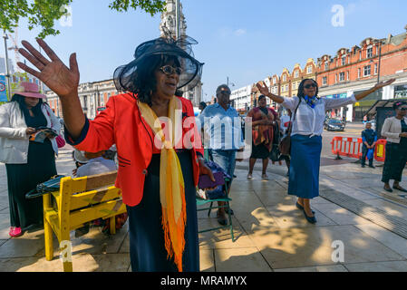 Londra, Regno Unito. 26 maggio 2018. Persone riase le loro mani per la musica di un coro gospel alla Brixton La Chiesa Avventista del Settimo Giorno 'Essere il cambiamento' evento in Piazza Windrush, Brixton contro la pistola e il coltello della criminalità. Essi avevano marciato la breve distanza della piazza della chiesa e sono state appena iniziando un programma di canto gospel, presentazioni e la preghiera per la comunità e per coloro che sono colpiti da questi crimini. Londra il tasso di omicidi è aumentata di oltre un terzo negli ultimi tre anni e lo scorso anno ha visto un aumento del 22% registrato nella criminalità coltello e 11% nella pistola criminalità. Foto Stock