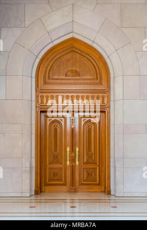 Legno complessamente intarsiato porta in un tradizionale stile arabo trovati all'entrata di un nuovo edificio in Muscat Oman Foto Stock