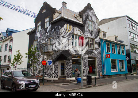 Case dipinte con colori vivaci a Laugavegur, Reykjavík, Islanda. 2018. Turisti e turisti stranieri si godono i murales Street art e visitare negozi colorati; vecchie case colorate nella sezione turistica del centro della città. Foto Stock