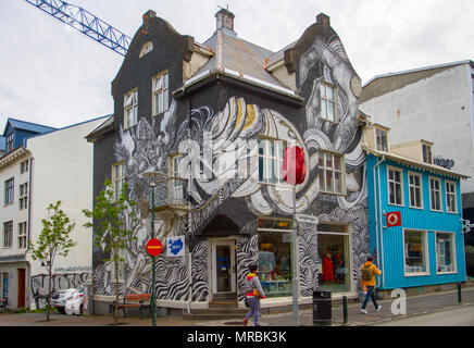 Case dipinte con colori vivaci a Laugavegur, Reykjavík, Islanda. 2018. Turisti e turisti stranieri si godono i murales Street art e visitare negozi colorati; vecchie case colorate nella sezione turistica del centro della città. Foto Stock