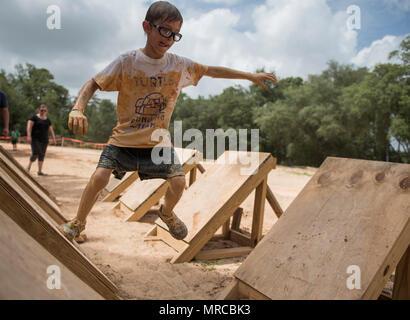 Aidan Flippo, pilota per un giorno candidato, completa un ostacolo durante una carità fango-run 20 maggio 2017, a Niceville, Florida. Flippo è stata selezionata per essere la trentatreesima Fighter Wing il pilota per un giorno. Aidan è nato con ottica Septo displasia effetti che i suoi occhi e reni. Durante la sua giornata ha incontrato F-35 piloti, ha girato un aeromobile, ha lavorato con un aeromobile con i manutentori e molto di più. (U.S. Air Force photo by Staff Sgt. Peter Thompson) Foto Stock