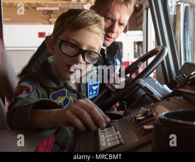 Aidan Flippo, pilota per un giorno candidato, spinge la sirena in un camion dei pompieri 25 maggio 2017, a Eglin Air Force Base in Florida. Flippo è stata selezionata per essere la trentatreesima Fighter Wing il pilota per un giorno. Aidan è nato con ottica Septo displasia effetti che i suoi occhi e reni. Durante la sua giornata ha incontrato F-35, i piloti hanno girato il velivolo, ha lavorato con un aeromobile con i manutentori e molto di più. (U.S. Air Force photo by Staff Sgt. Peter Thompson) Foto Stock