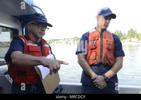 Il cap. Sean Croce (a destra), capo della risposta, Coast Guard tredicesimo distretto, ascolta come Kent Brown, un coxwain con la Guardia Costiera distretto ausiliario 13, flottiglia 1-2, conduce una breve di sicurezza prima di uscire dal combustibile navale deportare in Manchester, nello Stato di Washington, 6 giugno 2017. Funzionari della Guardia Costiera e Army Corp di ingegneri osservato un versamento congiunto esercizio off a Blake Island dal marrone la nave. Stati Uniti Coast Guard foto di Sottufficiali di terza classe Amanda Norcross. Foto Stock