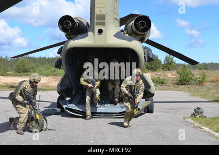 ADAZI base militare, LETTONIA - REGNO UNITO il Royal Marine Commando corsa fuori della CH-47 Chinook in una sessione di carica fredda formazione, tamponi di elicottero, Adazi, 2 giugno. Carico a freddo la formazione è la pratica di entrare o di uscire dall'aeromobile mentre l'aeromobile viene arrestato. La formazione e l'aeromobile è fornito dal decimo combattere la Brigata Aerea soldati attualmente in Lielvarde, Lettonia. Il corso di formazione è quello di preparare un evento imminente durante l'esercizio Saber Strike, che includerà il caricamento rapido e offloading di personale. Saber Strike è un U.S. Esercito Europa-led multinazionale di forze combinate tra Foto Stock