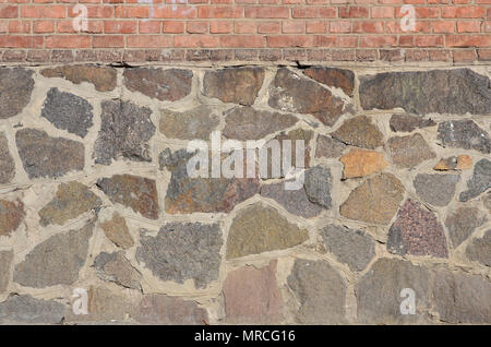 Muro di pietra di sfondo - costruzione di funzione. Texture di spessore e forte a muro di pietre grezze di varie forme e dimensioni Foto Stock