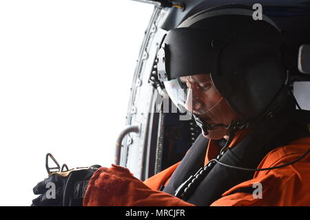 Petty Officer di prima classe Cimbak Justin, un aviazione tecnico di manutenzione a Coast Guard Settore San Diego, si prepara per un paranco a bordo di un MH-60 elicottero Jayhawk nel corso di una ricerca comune e di esercitazione di soccorso con la marina militare messicano al largo della costa di Ensenada, in Messico il 7 giugno 2017. L'esercizio simulato una nave fire che richiede un coordinamento internazionale di ricerca e di salvataggio.(STATI UNITI Coast Guard foto di Sottufficiali di terza classe Joel Guzman) Foto Stock