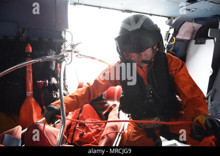 Petty Officer di prima classe Cimbak Justin, un aviazione tecnico di manutenzione a Coast Guard Settore San Diego, prepara il cestello di recupero per un paranco a bordo di un MH-60 elicottero Jayhawk nel corso di una ricerca comune e di esercitazione di soccorso con la marina militare messicano al largo della costa di Ensenada, in Messico il 7 giugno 2017. L'esercizio simulato una nave fire che richiede un coordinamento internazionale di ricerca e di salvataggio. (U.S. Coast Guard foto di Sottufficiali di terza classe Joel Guzman) Foto Stock