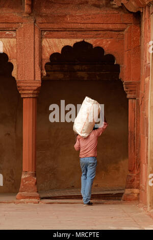 Agra, India - 29 Novembre 2015: Un uomo indiano che trasportano 'n sacchetto sulla sua spalla nello storico Forte Rosso di Agra - un sito patrimonio mondiale dell'UNESCO Foto Stock