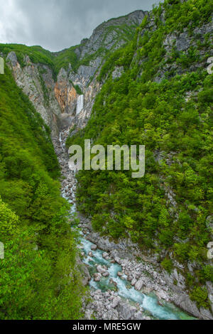 Lontano, imponente cascata a cascata verso il basso ripidi pendii rocciosi all inizio della gola.lussureggianti foreste coprono le montagne, massi la linea riverbed Foto Stock