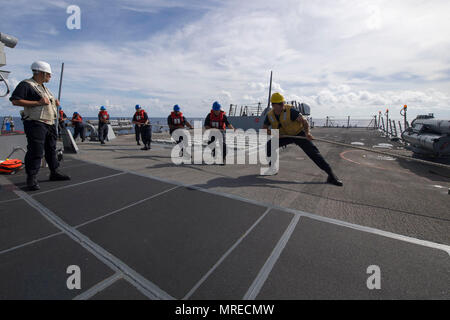 170609-N-ZW825-148 sul Mare del Sud della Cina (9 giugno 2017) i gestori di linea a bordo Arleigh Burke-class guidato-missile destroyer USS Sterett (DDG 104) heave intorno a una linea di trasporto di carichi secchi e munizioni nave USNS Richard E. Byrd (T-AKE 4) durante un rifornimento in mare. Sterett è parte della superficie Sterett-Dewey Action Group ed è il terzo gruppo di distribuzione che operano sotto il comando ed il controllo costrutto denominato 3a flotta in avanti. Stati Uniti 3a flotta operante in avanti offre opzioni aggiuntive per la flotta del Pacifico commander sfruttando le capacità del 3° e 7° flotte. (U.S. Foto di Marina di Massa Communica Foto Stock