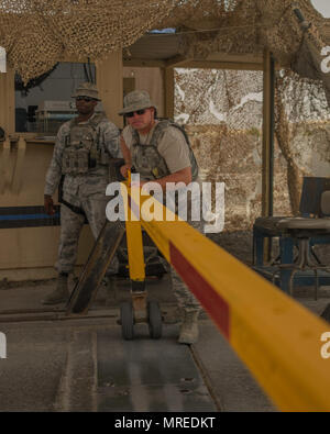 Senior Airman Brody, destro 380 Expeditionary forze di sicurezza squadrone voce installazione controller, apre un gate Giugno 7, 2017, in una località segreta nel sud-est asiatico. Avieri in 380 FSE servire un ruolo chiave nella difesa fisicamente l'installazione. (U.S. Air Force foto di Senior Airman Preston Webb) Foto Stock