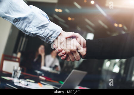 Due uomini strette di mano dopo importanti conferenze di affari nella moderna sala loft Foto Stock