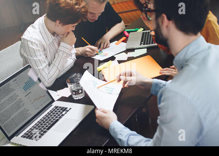 Il gruppo di marketing è il pensiero di un nuovo piano di sviluppo. I giovani imprenditori discutono di pianificazioni e schemi Foto Stock