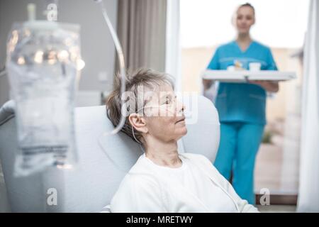 Senior donna con cannula nasale e la sacca per infusione. Foto Stock