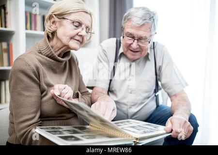 Coppia senior guardando album di foto. Foto Stock