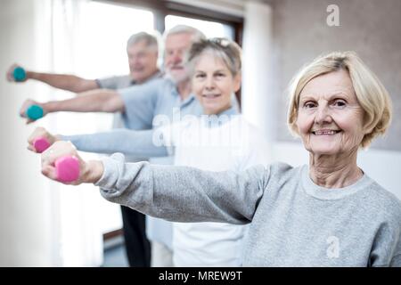 Adulti senior di contenimento dei pesi a mano. Foto Stock