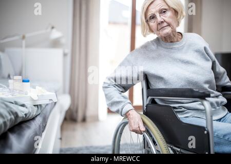 Senior donna in sedia a rotelle in casa di cura. Foto Stock
