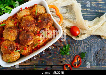Succose le polpette di carne in una piccante salsa di pomodoro su un tavolo di legno. Piatto di carne macinata. Vista superiore Foto Stock
