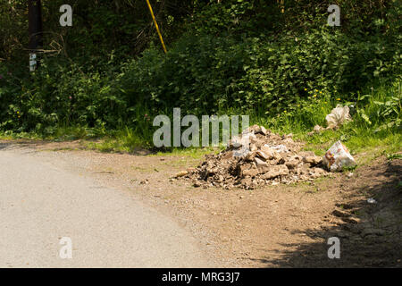 Le macerie e sacchetti oggetto di dumping in un vicolo del paese in ingresso ad una porta che conduce ad una linea ferroviaria nel nord Inghilterra Dorset Regno Unito GB Foto Stock