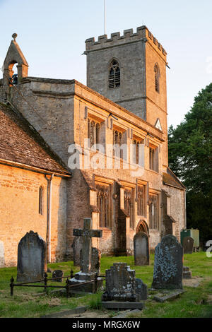 Sera La luce del sole su St Leonard chiesa nel villaggio di Bledington, Cotswolds, Gloucestershire, Inghilterra Foto Stock