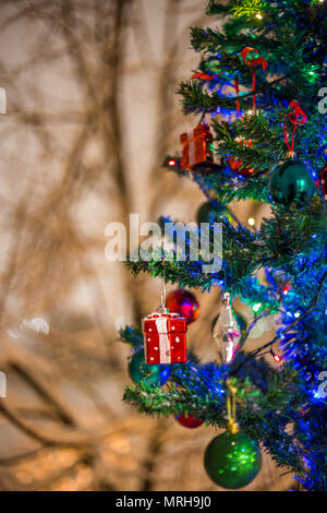 Le decorazioni di Natale su un ramo di abete, notte idillio, con neve e lampade in vari colori Foto Stock