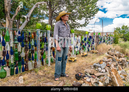 Tom Larson, l'eccentrico proprietario della bottiglia casa in Golden, Nuovo Messico. La struttura dispone di bottiglie appeso in recinzioni, sugli alberi e in molti luoghi. T Foto Stock