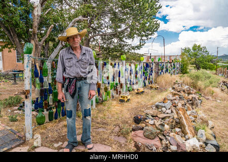 Tom Larson, l'eccentrico proprietario della bottiglia casa in Golden, Nuovo Messico. La struttura dispone di bottiglie appeso in recinzioni, sugli alberi e in molti luoghi. T Foto Stock