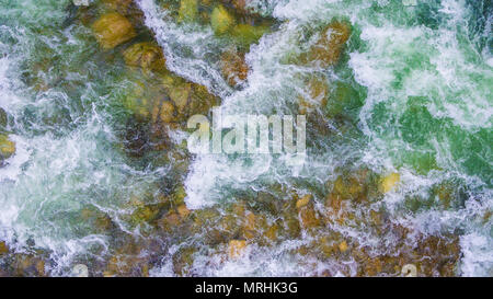 Top-down drone vista di rapide del fiume di montagna con massi umido sul fondo Foto Stock