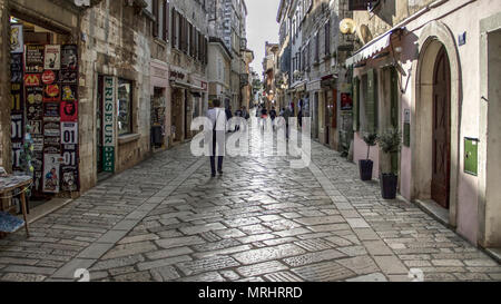 Istria, Croazia, Aprile 2018 - i turisti e i locali a piedi giù per la strada di ciottoli nel centro storico di Porec al crepuscolo Foto Stock