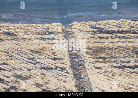 Vista su rocce esposte sulla spiaggia (popolare con i cacciatori di fossili) a bassa marea da scogliere a Saltburn dal mare, North Yorkshire, Inghilterra, Regno Unito Foto Stock