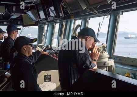 170618-N-ZW825-075 Subic Bay, Repubblica delle Filippine (18 giugno 2017) della Cmdr. Claudine Caluori, Comandante della Arleigh Burke-class guidato-missile destroyer USS Sterett (DDG 104) osserva come la nave transita a Subic Bay, Repubblica delle Filippine per la programmata visita porta. Sterett è parte della superficie Sterett-Dewey Action Group ed è il terzo gruppo di distribuzione che operano sotto il comando ed il controllo costrutto denominato 3a flotta in avanti. Stati Uniti 3a flotta operante in avanti offre opzioni aggiuntive per la flotta del Pacifico commander sfruttando le capacità del 3° e 7° flotte. (U.S. Navy Foto Stock