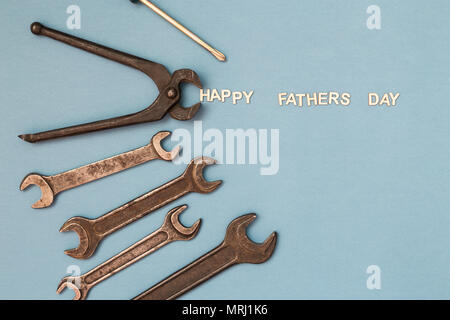 La festa del papà concetto card con il lavoro dell'uomo strumenti su sfondo grigio e iscrizione felice Festa del papà. Vista dall'alto. Foto Stock