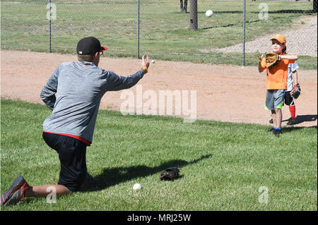 Eric Mason, YMCA di Pikes Peak Regione coordinatore sport getta un baseball da Andrew Canaan, 5, durante un YMCA-hosted sports clinic a Schriever Air Force Base in Colorado, Lunedì 19 Giugno, 2017. Il cinquantesimo forza squadrone di supporto ha collaborato con la Y per portare un settimanale sports clinic alla base il lunedì, il mercoledì e il venerdì di estate dove i bambini 4-14 possono imparare le abilità sportive. (U.S. Air Force foto/Staff Sgt. Wes Wright) Foto Stock