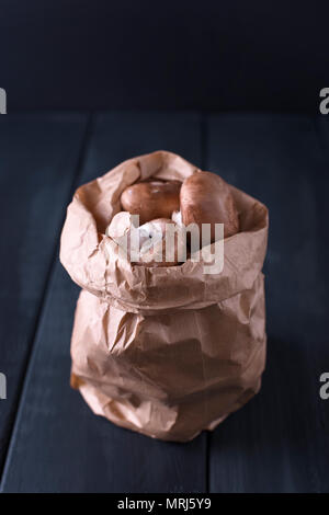 Funghi champignon in un sacchetto di carta, sullo sfondo. Spazio di copia Foto Stock