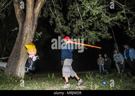 Fotoreporter Luis Gutierrez de Norte foto e biologi provenienti dagli Stati Uniti e Messico, strappo con un bastone di legno, un Donald Trump piñata. Foto Stock