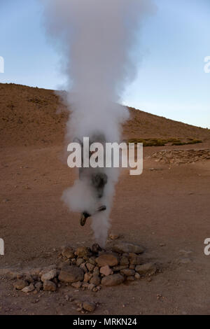 Giovane uomo a geyser Sol de Manana a Eduardo Avaroa fauna Andina riserva nazionale in Bolivia Foto Stock