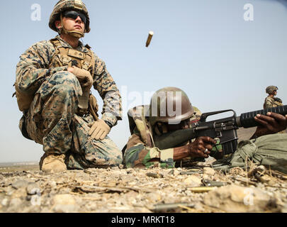 Cpl. Seth Carney, un rifleman con scopi speciali Air-Ground Marine Task Force - Risposta in caso di crisi - Africa, osserva che la precisione di un soldato con il Senegal di quinta contingente in Mali durante una delle operazioni di mantenimento della pace di formazione missionaria a Thies, Senegal, 9 giugno 2017. Marines e marinai con SPMAGTF-CR-AF è servita come istruttori e progettato il corso di formazione per migliorare il soldato' abilità per distribuire con successo a sostegno delle Nazioni Unite alle missioni di mantenimento della pace nel continente. (U.S. Marine Corps foto di Sgt. Samuel Guerra/rilasciato) Foto Stock