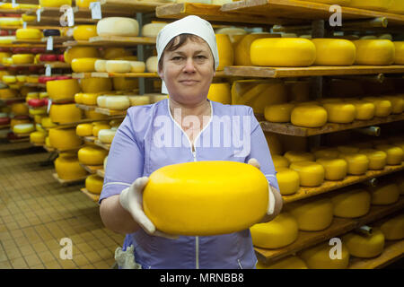 Vvillage Novonikolskoe, Michurin, Regione di Tambov, Russia. 27 Maggio, 2018. La maturazione del formaggio camera. Nella foto-una donna tenendo un formaggio Credit: Aleksei Sukhorukov/ZUMA filo/Alamy Live News Foto Stock