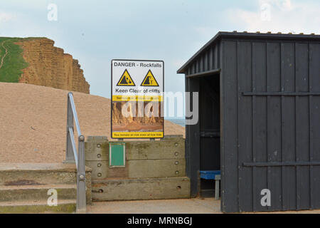 Dorset, Regno Unito. 26 maggio 2018. May Bank Holiday Weekend. Da sola persona sorge sulla sommità di scogli pericolosi a West Bay nel Dorset dove in passato le parti della famosa scogliera hanno dato modo. Cartelli di avvertimento sono stati messi in atto dal indicando i pericoli ma ancora persone si mettono a rischio e altri al di sotto. Robert Timoney/Alamy/Live/News Foto Stock