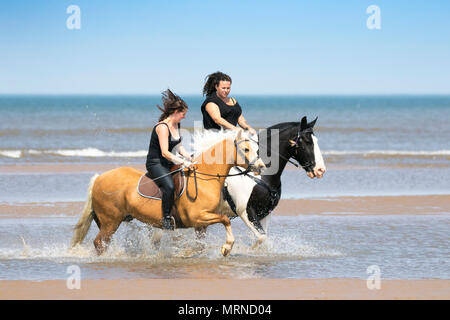 Cavalieri a Southport, Regno Unito. 27 maggio 2018. Meteo Regno Unito. Durante una bella vacanza in riva al sole Domenica pomeriggio, Kirsten Hall [L] e Kay Egerton [R] da Blackburn cavalcano i loro amati cavalli lungo la marea in arrivo sulle sabbie dorate della spiaggia di Southport a Merseyside. Credit: Cernan Elias/Alamy Live News Foto Stock