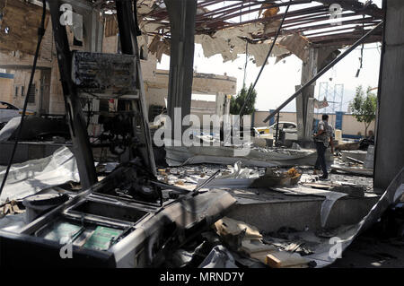 Sanaa, Yemen. 27 Maggio, 2018. Un uomo cammina dentro la sede dello stato-run Oil Company dopo che essa è stata colpita da incursioni aeree in Sanaa, Yemen, il 27 maggio 2018. Almeno quattro civili sono stati uccisi quando Saudi-led incursioni aeree della coalizione ha colpito la sede dello stato-run Oil Company e casali vicini nella capitale yemenita Sanaa sabato sera, funzionari residenti e soccorritori detto. Credito: Mohammed Mohammed/Xinhua/Alamy Live News Foto Stock