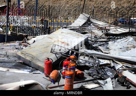 Sanaa, Yemen. 27 Maggio, 2018. Un uomo dietro un recinto guarda al relitto del quartier generale dello stato-run Oil Company dopo che essa è stata colpita da incursioni aeree in Sanaa, Yemen, il 27 maggio 2018. Almeno quattro civili sono stati uccisi quando Saudi-led incursioni aeree della coalizione ha colpito la sede dello stato-run Oil Company e casali vicini nella capitale yemenita Sanaa sabato sera, funzionari residenti e soccorritori detto. Credito: Mohammed Mohammed/Xinhua/Alamy Live News Foto Stock