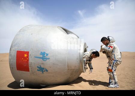 (180527) -- LANZHOU, 27 maggio 2018 (Xinhua) -- Taikonauts Nie Haisheng (L) e Liu Wang esce da una capsula di rientro durante un deserto per la sopravvivenza della formazione in Badain Jaran deserto nel nord-ovest della Cina di Provincia di Gansu, 17 maggio 2018. Quindici taikonauts cinesi hanno appena completato il deserto di formazione di sopravvivenza nel profondo del Badain Jaran deserto vicino Jiuquan Satellite Launch Center nel nord ovest della Cina. Organizzato dall'astronauta centro della Cina (ACC), il programma è stato concepito per preparare taikonauts con la capacità di sopravvivere nel deserto in caso la loro capsula di rientro terre al di fuori del target. (X Foto Stock