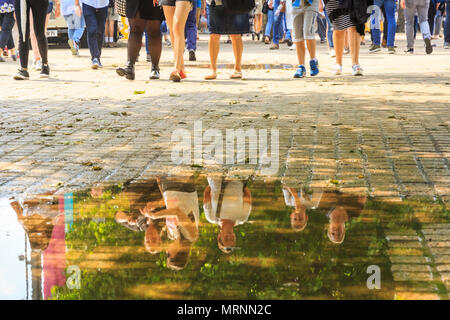 South Bank di Londra, 27 maggio 2018. Il caldo sole porta fuori dalla folla di londinesi e turisti per una passeggiata lungo la riva sud del fiume Tamigi che ha ancora pozzanghere di acqua piovana da ultima notte di tempesta. A seguito di una notte con forti tuoni e pioggia torrenziale, Londra ha visto calda umida temperature e sole sulla Bank Holiday Domenica. Foto Stock