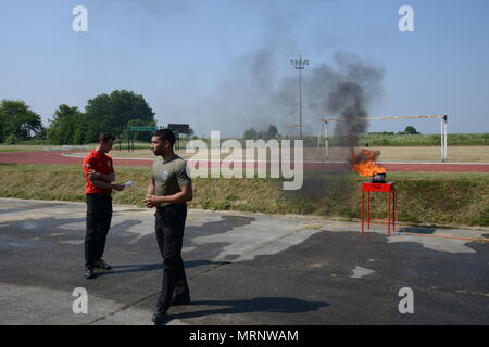 Ispettore antincendio Andy Daie e Carl Sauvage, assegnato a U.S. Army Garrison Benelux' Dipartimento di servizi di emergenza, spiegare come arrestare un grasso incendio in una cucina durante la giornata di sicurezza, Wingene Air Base, Belgio, 01 giugno 2017. (U.S. Esercito foto di Visual Information Specialist Pascal Demeuldre) Foto Stock