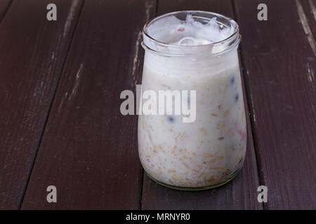 Una sana prima colazione - yogurt con mirtilli e muesli servita in un barattolo di vetro, Lazy fiocchi d'avena Foto Stock