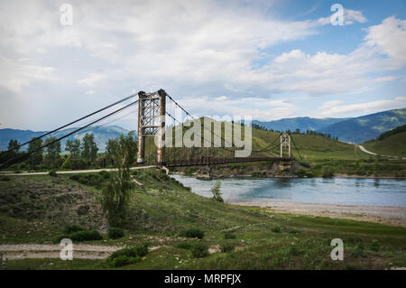 Sospensione in legno ponte su un fiume di montagna in alto nelle montagne di Altai. Foto Stock